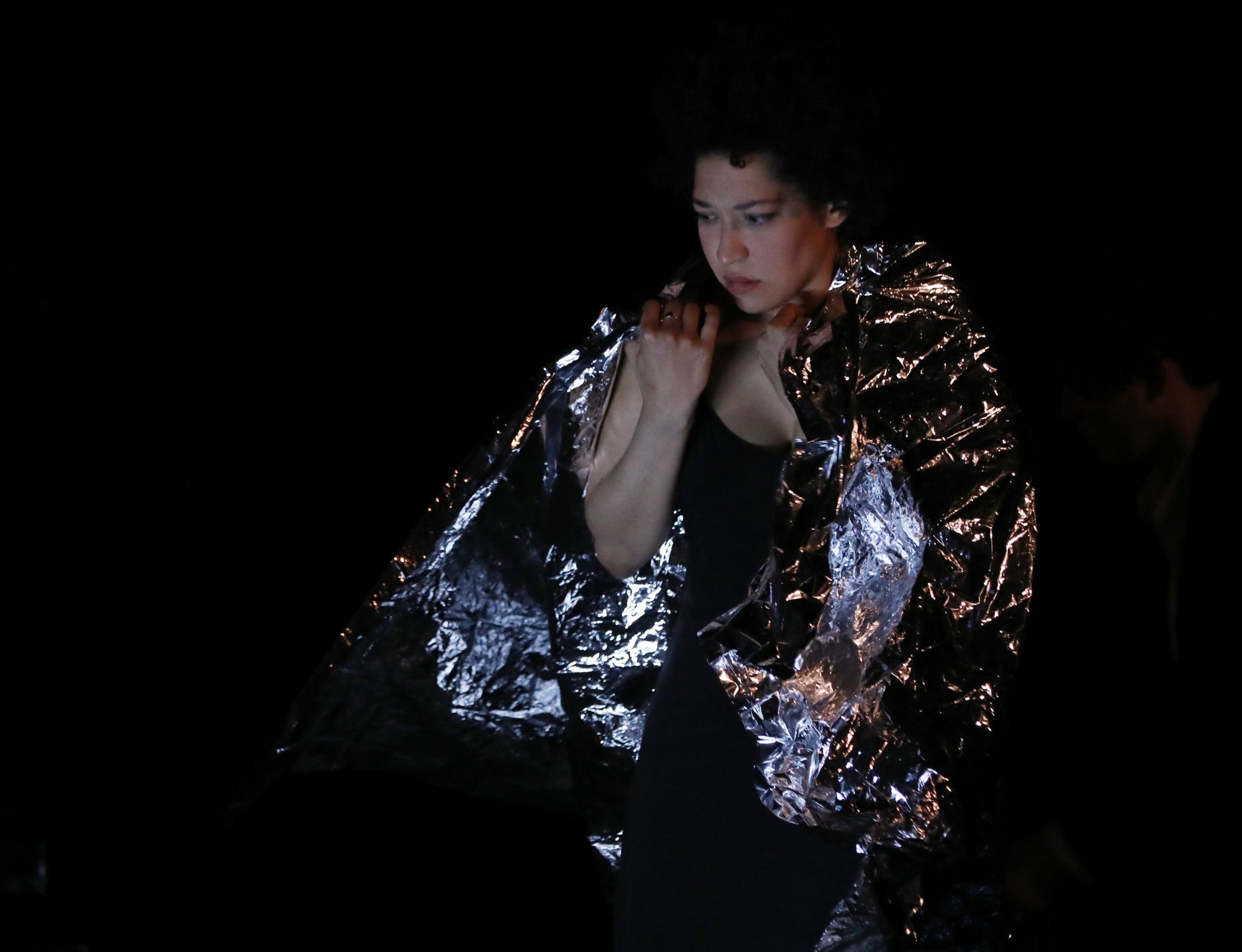 Julia Bullock looks down worriedly, with a metallic blanket around her shoulders.